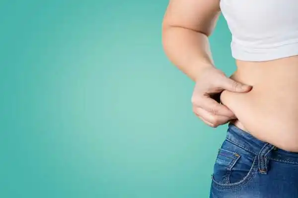 Image of woman pinching her love handles to show weight gain Hampton